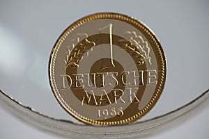 Closeup of a gold German Mark coin from the year 1966 on a white surface