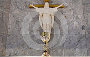 Closeup of Golden Chalice in The Catholic Church with Jesus Christ background