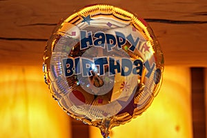 Closeup of a golden round mylar birthday balloon