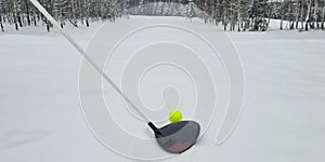 Closeup of golf ball and club in snow