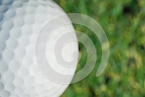 Closeup on a golf ball on green grass