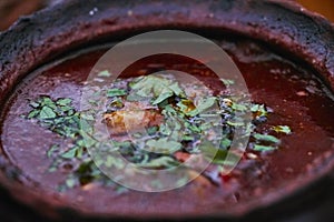 Closeup of a goulash meal in a cast iron kettle.