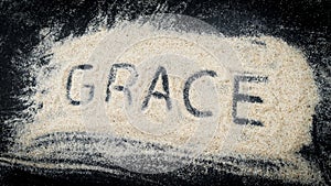 Closeup of GRACE word written on white sand