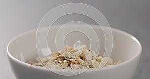 Closeup granola with almond flakes in white bowl