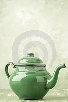 Closeup of a green enameled retro teapot