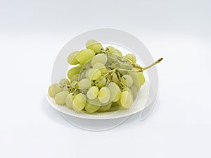 Closeup of green grapes in a plate isolated on a white background