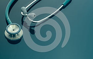 Closeup green stethoscope on doctor table or nurse desk. Health checkup or health insurance concept. Cardiology doctor equipment.