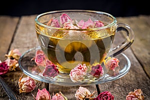 Closeup of green tea cup with dried rose buds