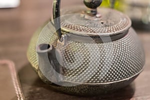 Closeup of green tea pot in table