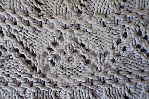 Closeup of grey handmade knitted fabric with zigzag pattern photo