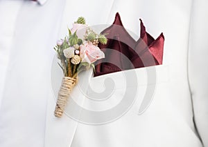 Closeup of groom boutonniÃ¨re on suit lapel