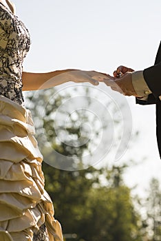 Closeup of groom placing a wedding ring on his brides finger
