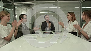 Closeup of group of business people applauding at a meeting