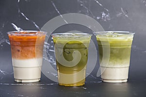 Closeup a group of iced tea drinks thai milk tea matcha latte and yuzu green tea served in plastic glass isolated dark background