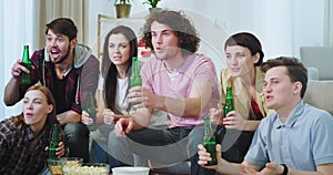 Closeup group of multi ethnic friends celebrating the victory of their best football team in front of TV they watching