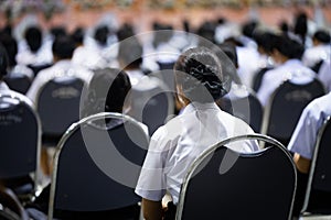 Closeup of a group of school-aged students wearing their school uniforms sitting during a conference