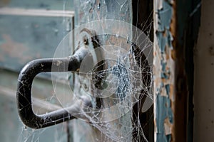 closeup of grubby door handle with cobwebs