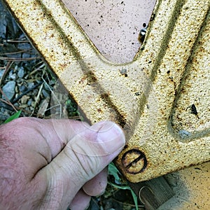 Closeup of grubby thumb next to screw