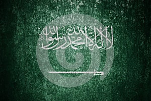 Closeup of grunge Saudi flag. Dirty Saudi Arabia flag on a metal surface