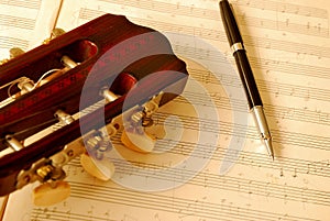 Closeup of guitar with pen on music manuscript