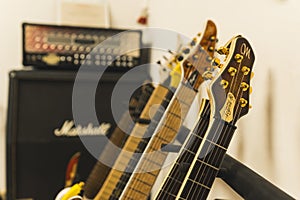 closeup of guitars headstocks and voice amplifiers in the background
