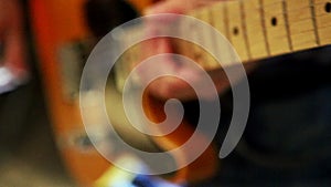 Closeup Guy Runs Fingers over Guitar Neck in Studio