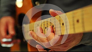 Closeup Guy Runs Fingers Slowly over Guitar Neck in Studio