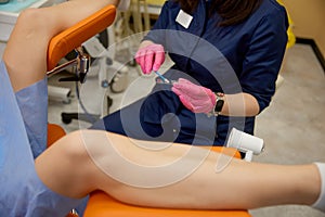 Closeup gynecologist taking test swabs for analysis at gynecological examination