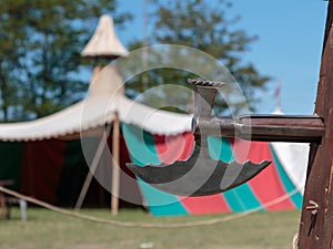 Closeup of Halberd, Medieval Pole Weapon and Tent in background