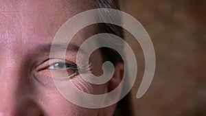 Closeup half-face portrait of beautiful adult female gray eye looking straight at camera. Smiling facial expression