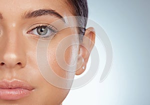 Closeup half face portrait of beautiful woman with smooth glowing skin and copyspace. Headshot of caucasian model