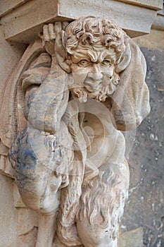 Closeup half naked faunus statue under column at Zwinger palace