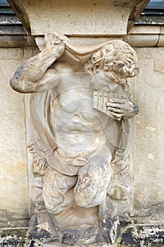 Closeup half naked satyr statue playing panpipe at Zwinger palace