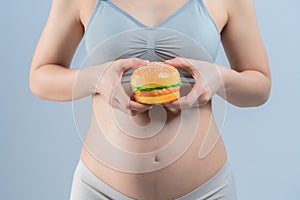 Closeup of hamberger junk food and pregnant woman is not good healthy for mother and infant