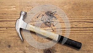 Closeup of a hammer and a pile of rivets, nails on white background