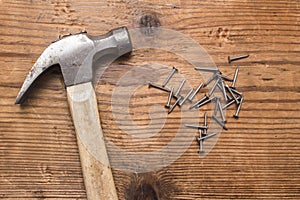 Closeup of a hammer and a pile of rivets, nails on white background