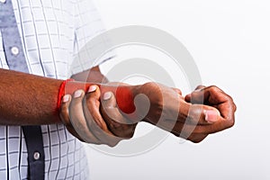 Black man holds his wrist hand injury, feeling pain