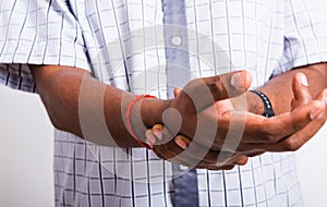 Black man holds his wrist hand injury, feeling pain