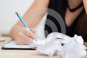 Closeup hand asian woman writer thinking idea and writing on notebook or diary with happy on desk office