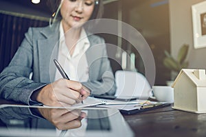 Closeup hand of business asian woman wearing face shield working from home