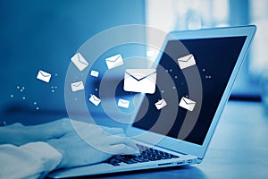 Closeup hand of businesswoman using a computer keyboard of sending email on blue tone