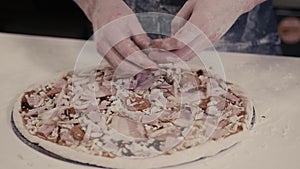 Closeup hand of chef baker in blue uniform making pizza at kitchen for delivery in modern restaurant