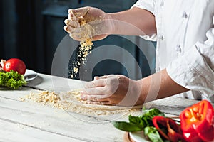 Closeup hand of chef baker in white uniform making pizza at kitchen