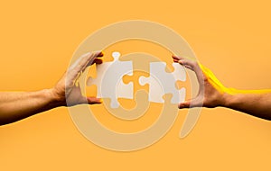 Closeup hand of connecting jigsaw puzzle. Business solutions, success and strategy concept. Two hands trying to connect