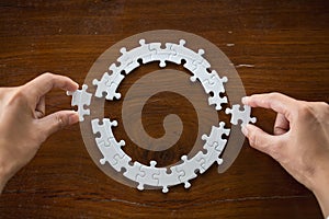 Closeup hand of connecting jigsaw puzzle to complete the mission with sunlight effect, Business solutions, success and strategy