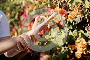 Closeup hand of couple woman and man doing asana yoga background swimming pool palm trees and sunlight. Concept of