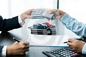 Closeup hand giving money for loan credit financial, lease and rental concept. Car dealers and protect against damage and risk of