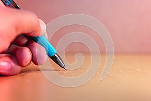 Closeup hand hold pen writing on desk
