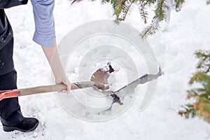 Closeup hand hold and using shovel scoop and cleared heap snow on floor