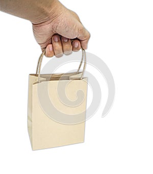 Closeup Hand holding blank kraft paper bag isolated on white background.The idea of â€‹â€‹not using plastic bags to help global